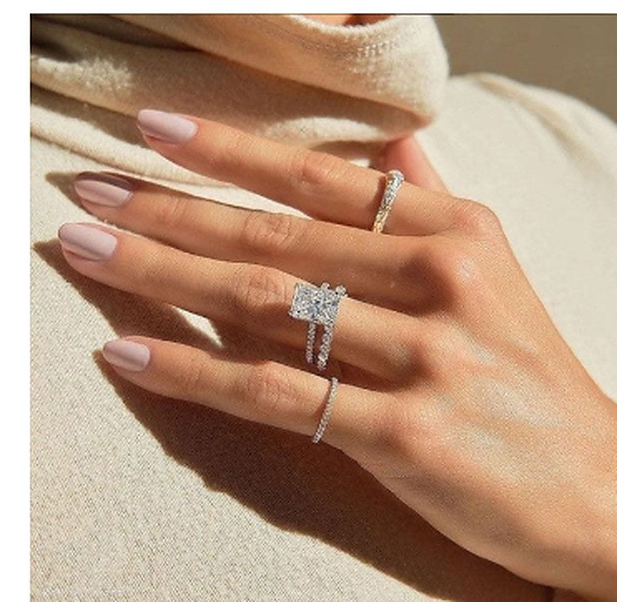 Hand wearing Holycome square and round moissanite rings in sterling silver and gold